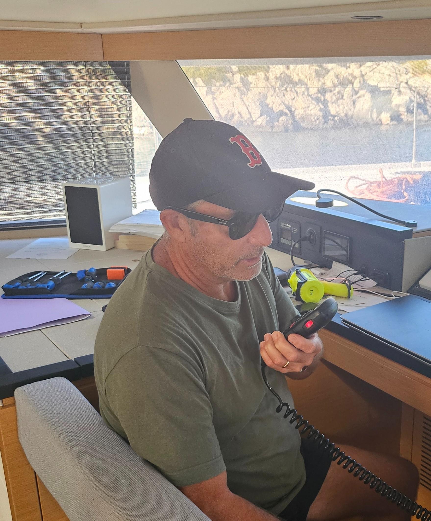Navigateur utilisant le combiné d’une radio VHF à bord d’un bateau